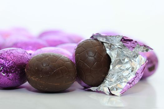 colorful wrapped chocolate easter eggs in close-up, macro