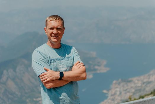 Man tourist enjoys the view of Kotor. Montenegro. Bay of Kotor, Gulf of Kotor, Boka Kotorska and walled old city. Travel to Montenegro concept. Fortifications of Kotor is on UNESCO World Heritage