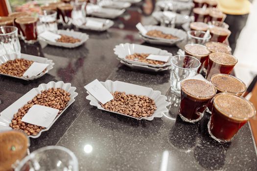 Close up of many coffee glasses and beans on table ready for a tasting indoors