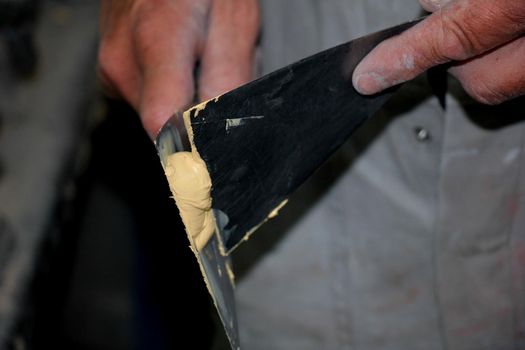 Man preparing filler in a vehicle repair shop