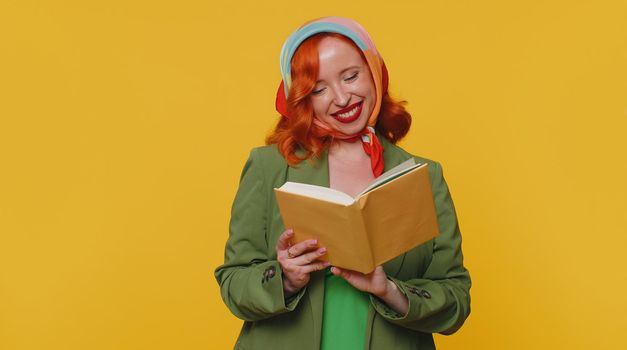 Redhead young woman reading funny interesting fairytale story book, leisure hobby, knowledge wisdom, education, learning, study, wow. Red hair ginger girl isolated alone on yellow studio background