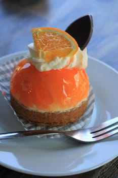 Fresh orange mousse confectionery, with cream and a chocolate decoration