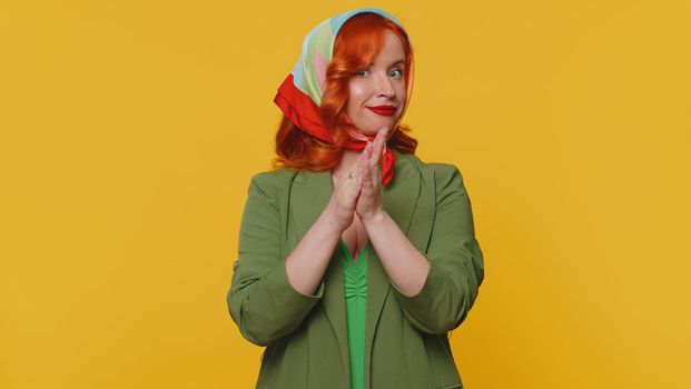 Great nice job. Cheerful positive happy woman in jacket showing thumbs up and nodding in approval, successful good work. Young stylish ginger girl on yellow studio background. People sincere emotions