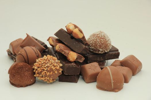 Different sorts of chocolates: bonbons and broken pieces of a chocolate bar