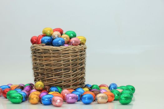 Foil wrapped chocolate easter eggs in a wicker basket