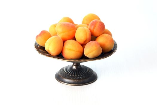 Heap of freshness apricots in vintage bowl on white background