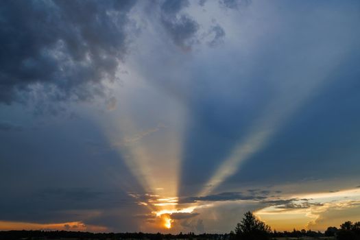 cloudy sunset sky with yellow sun rays without horizon, captured with 28mm lens