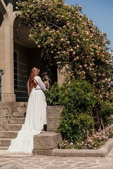 a beautiful woman in a white dress walks on a beautiful veranda