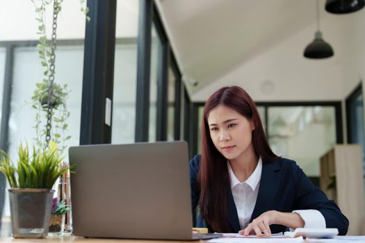 Portrait of a business woman using a computer to work on financial statements.