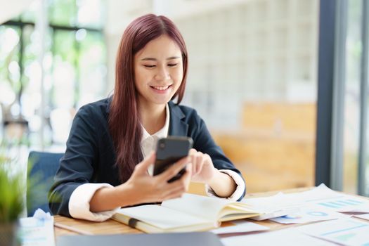 Asian businesswoman using the phone to contact a business partner.