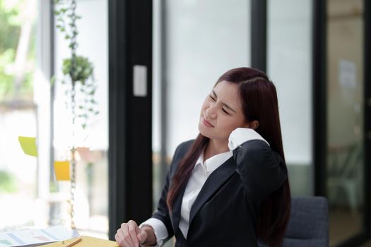 Portrait of an Asian businesswoman showing a headache from depression.