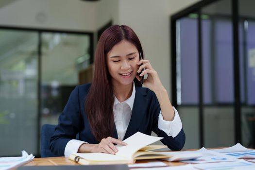 Asian businesswoman using the phone to contact a business partner.