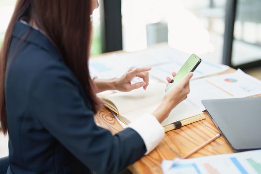 Asian businesswoman using the phone to contact a business partner.