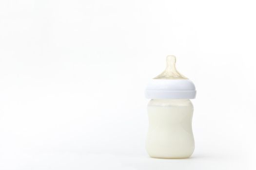 Isolated baby bottle feeding full of milk on white background with copy space