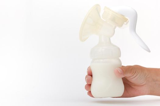 Isolated baby breast manual pump full of milk in cropped woman hand on white background with copy space