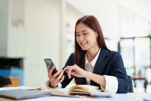 Asian businesswoman using the phone to contact a business partner.