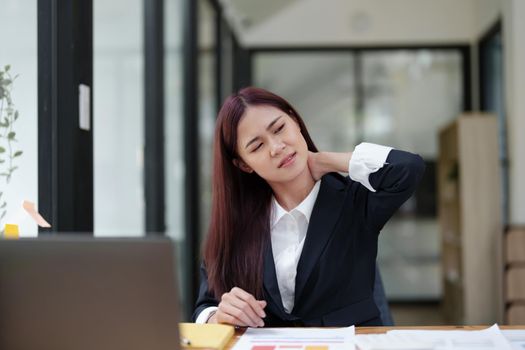 Portrait of an Asian businesswoman showing a headache from depression.