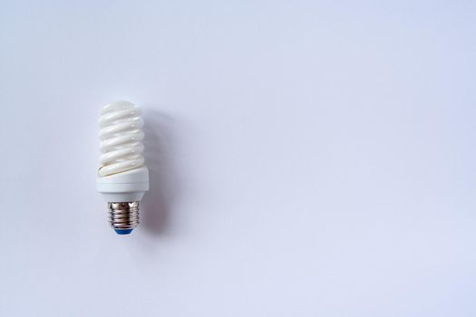 Energy saving light bulb on a blue background. Economical consumption of electricity. The concept of nature conservation