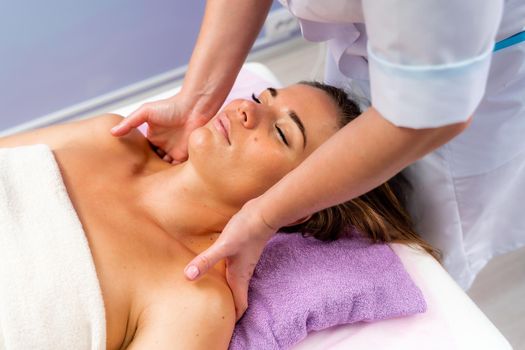 Facial massage. A woman is given a massage in a beauty salon. Close-up.