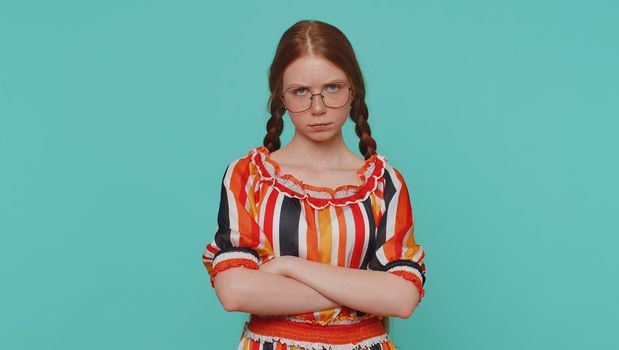 Dissatisfied girl shaking head No, asking reason of failure, expressing disbelief irritation, feeling bored, disappointed in result, bad news. Ginger teenager child isolated on blue studio background