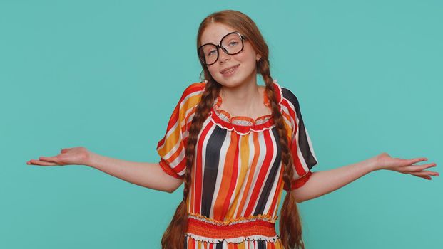 I dont know what to say. Confused redhead girl feeling embarrassed about ambiguous question, having doubts, no idea, being clueless and uncertain. Teenager ginger child kid on blue studio background