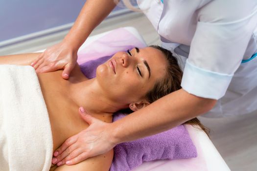 Facial massage. A woman is given a massage in a beauty salon. Close-up.