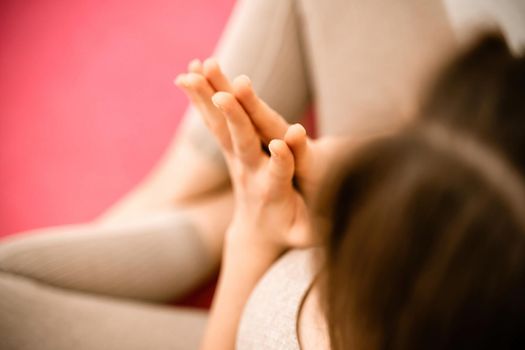 Girl does yoga. Young woman practices asanas on a beige one-ton background