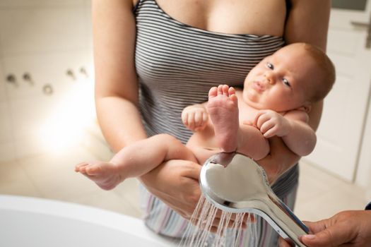 Mother washes her baby after stool at the bath
