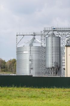 Modern large granary agro silos elevator on agro-processing manufacturing plant for processing drying cleaning and storage of agricultural products, flour, cereals and grain.