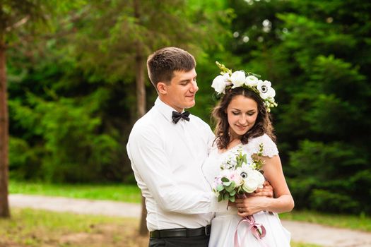 Happy bride and groom after wedding ceremony walking at the park and have photoshoot