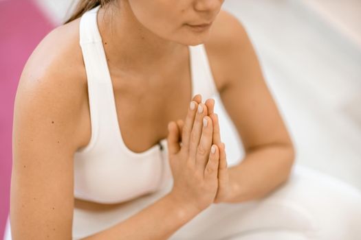 Girl does yoga. Young woman practices asanas on a beige one-ton background