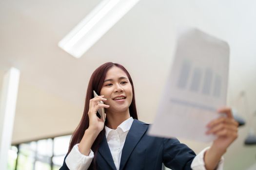 Asian businesswoman using the phone to contact a business partner.