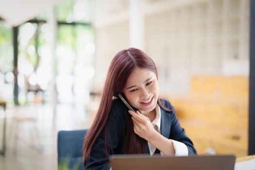 Asian businesswoman using the phone to contact a business partner.