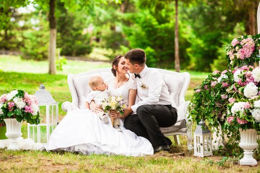 Happy wedding couple at the outdoor wedding decor and sofa