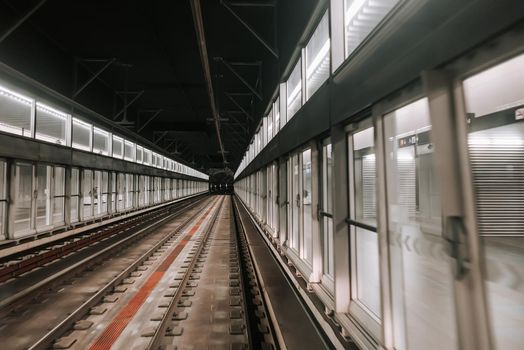 Moving unmanned subway - automatic metro station in Paris. Riding underground train in modern city. Modern public mode of transport. High quality photo