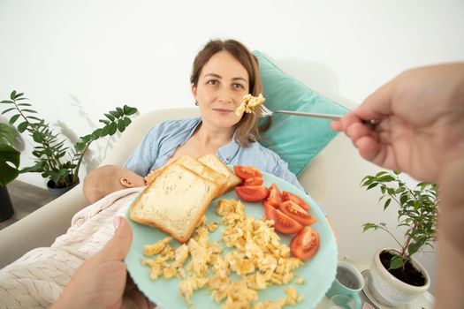 Elder woman helps to eat for new mother when she breastfeeds her baby. Motherhood support