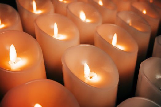 Candles burning brightly. Modern memorial candle on batteries in church. Abstract background. High quality photo