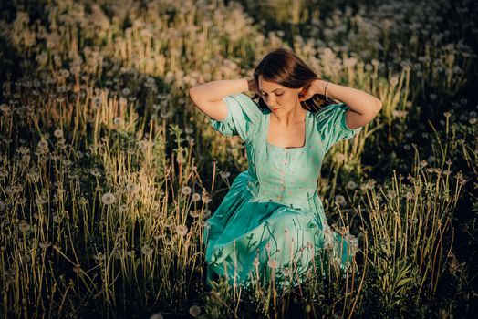 Portrait of young rural elegant woman posing on nature background. Sexy languid lady touching hair, enjoying summertime, sun rays. Vintage styled dress. High quality photo