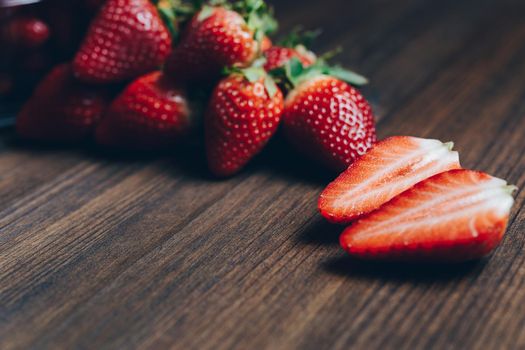 Fresh and juicy strawberries on wooden background in rustic style, healthy sweet food, vitamins and fruity concept. Copy space for text