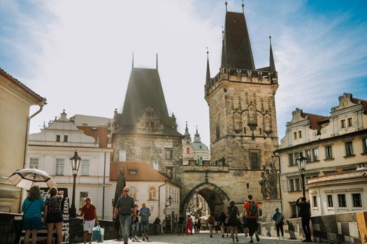 Prague, Czech Republic - July 2022. People tourists are walking on famous medieval Charles - Karlov bridge across Vltava river. Historic, old district of european capital. High quality photo