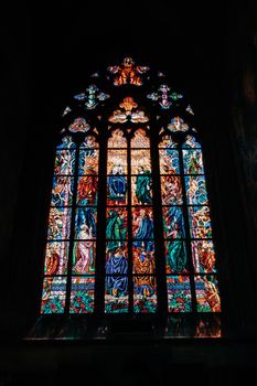 Prague, Czech Republic - July 2022. Amazing stained glass window in St. Vitus cathedral in Castle district. Colored flecks of sunlight. High quality photo