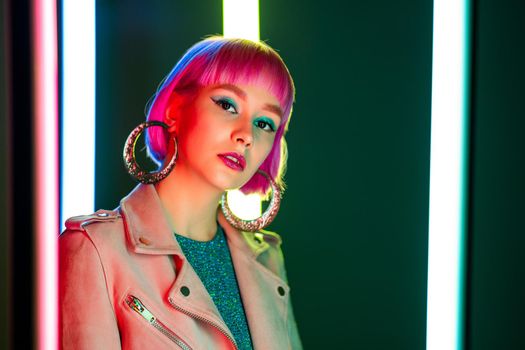 Portrait of glamorous woman with dyed pink hairstyle under neon light. Nightclub, trendy outfit. Teenager, zoomer Z-generation. High quality photo