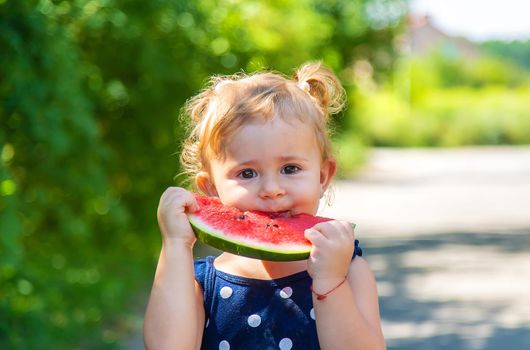 A child eats watermelon in the park. Selective focus. Kid.