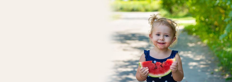 A child eats watermelon in the park. Selective focus. Kid.