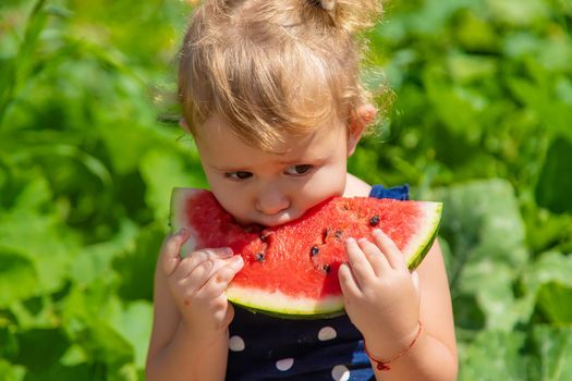 A child eats watermelon in the park. Selective focus. Kid.