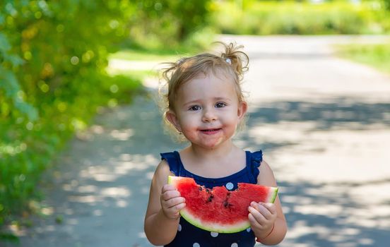 A child eats watermelon in the park. Selective focus. Kid.