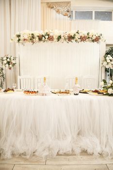 Wedding decor made of flowers and fabric. Beautiful decorations for newlyweds on their wedding day