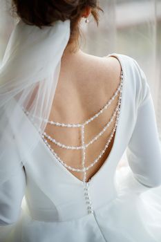 Bride zips zipper on her wedding white dress
