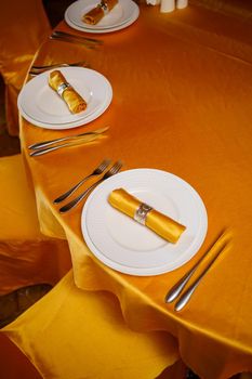 Elegant table setting with fork, knife and gold napkin