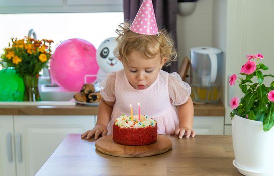 Child is two years old with a cake and candles. Selective focus. Kid.